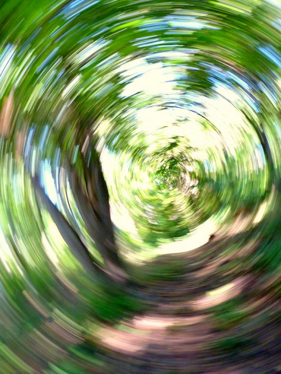 a blurry woodland path illustrates how the world looks during a vertigo attach
